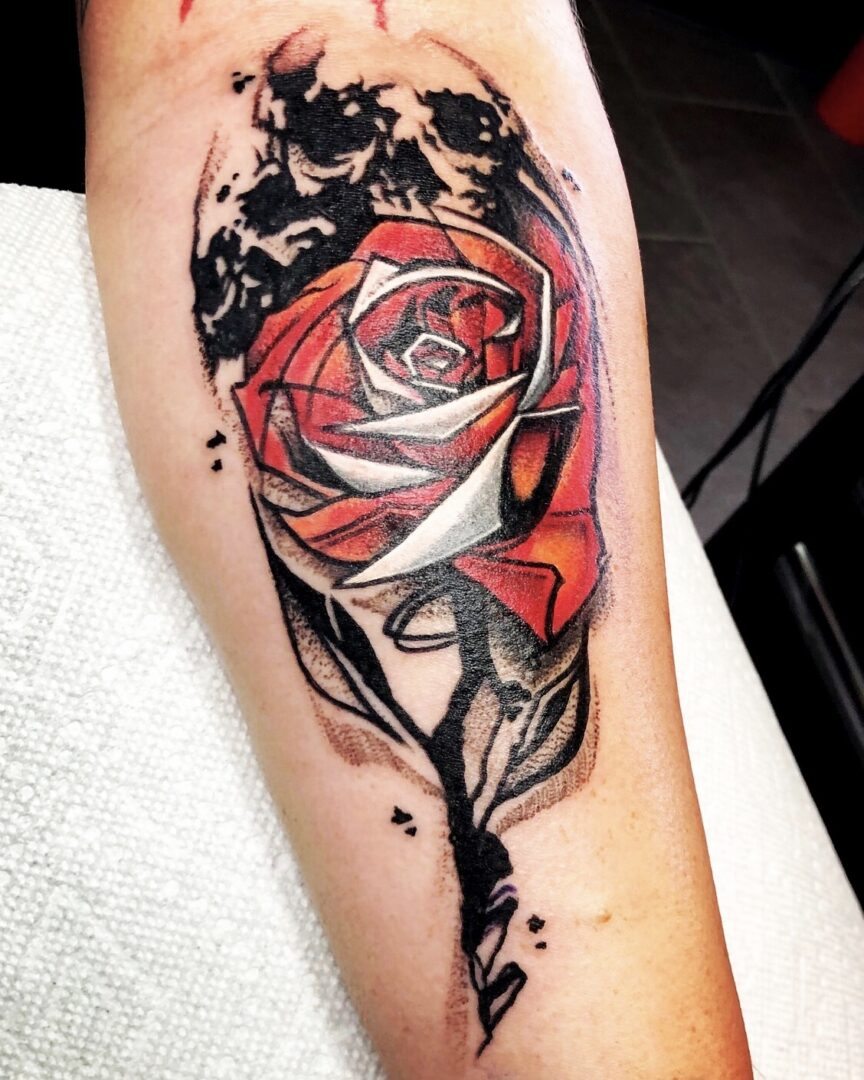 A tattoo of a rose with skulls and bones.