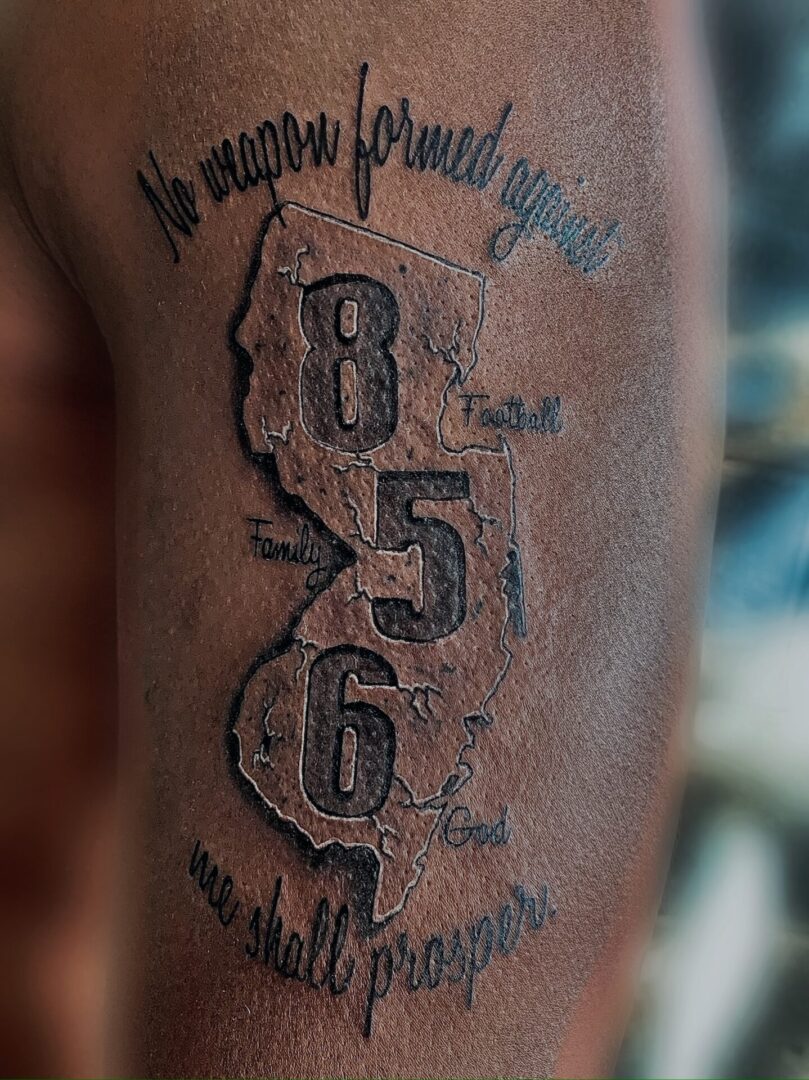 A tattoo of the state of new jersey with numbers 8 5 6 and 8 3 4.