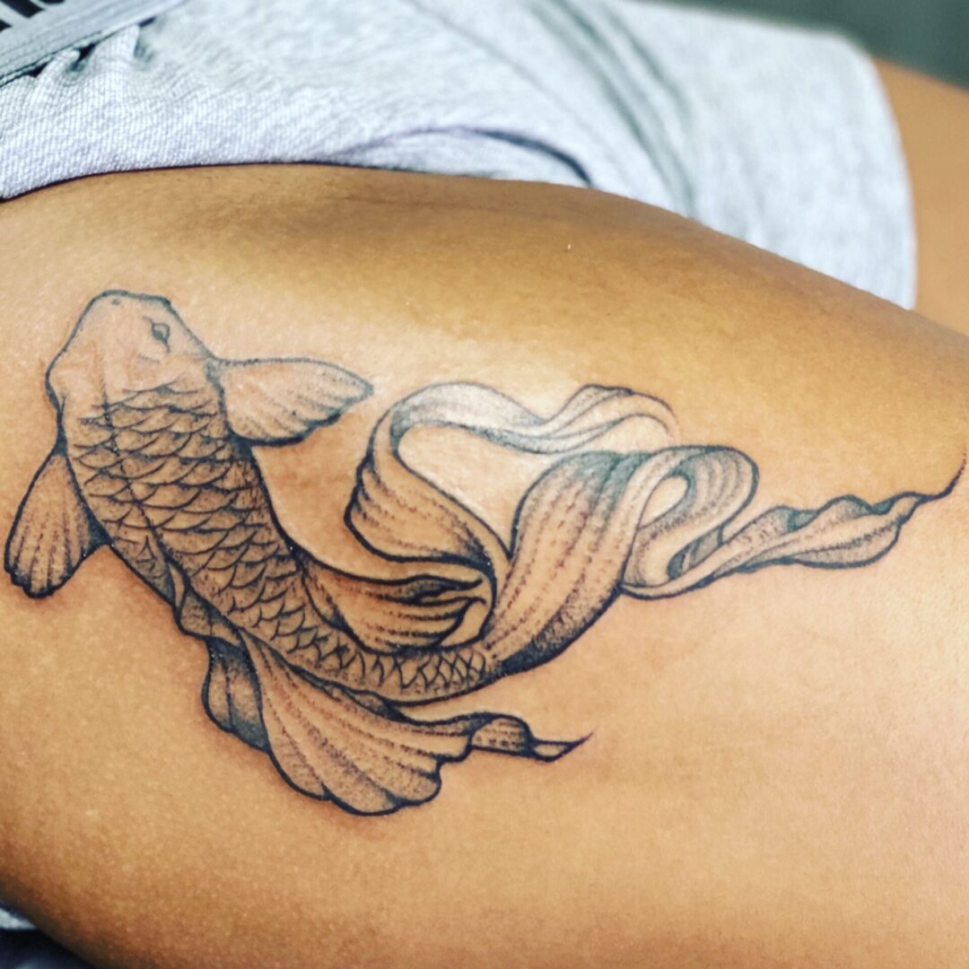 A fish tattoo is shown on the side of a woman 's leg.