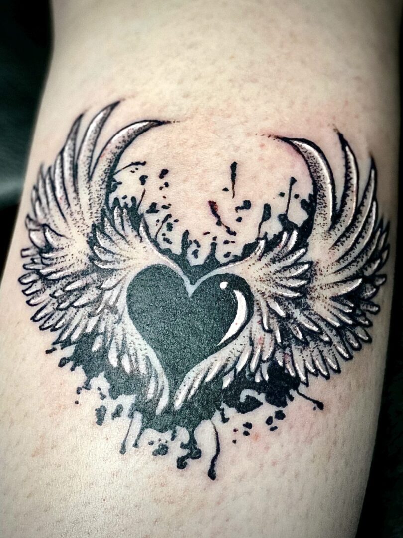 A tattoo of a heart with wings on it.