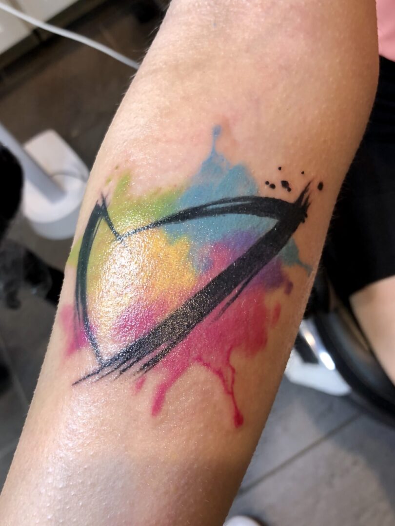 A colorful tattoo of an eye with paint splashes.