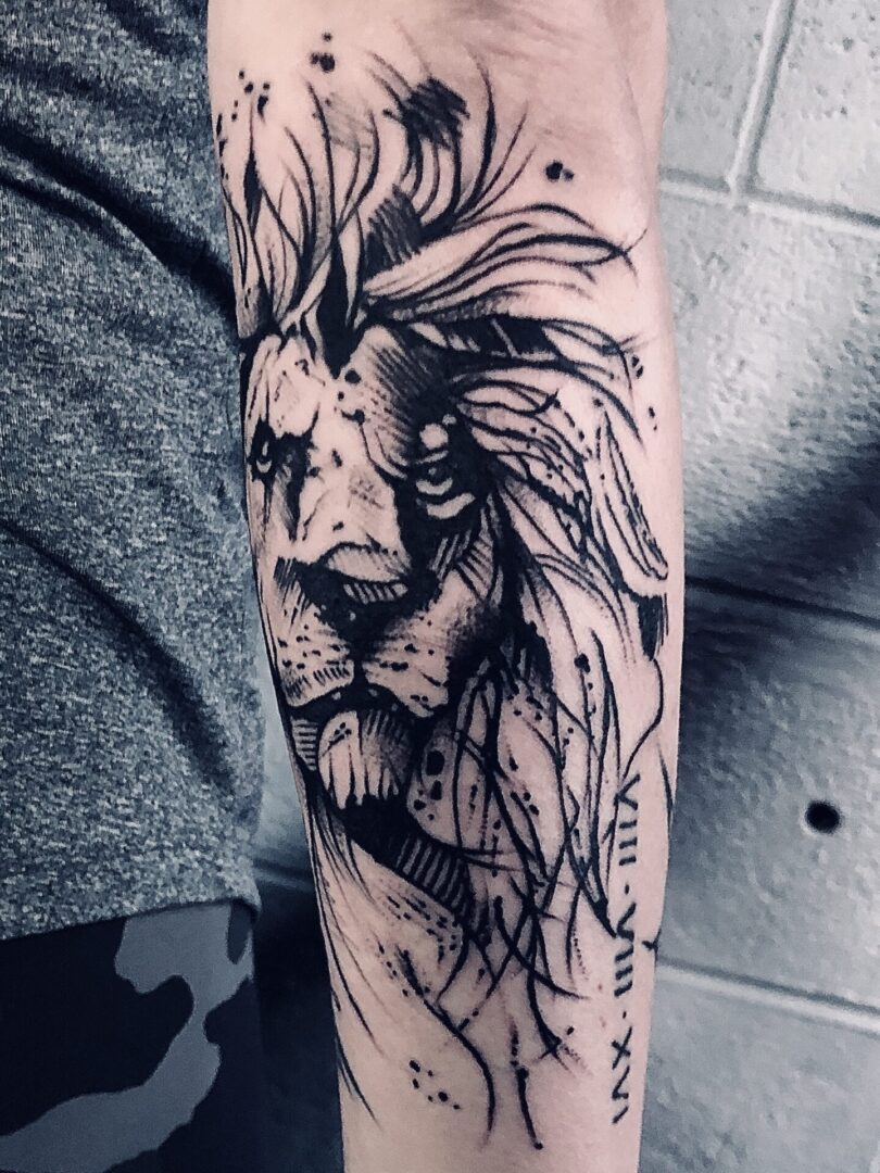 A black and white tattoo of a lion 's head