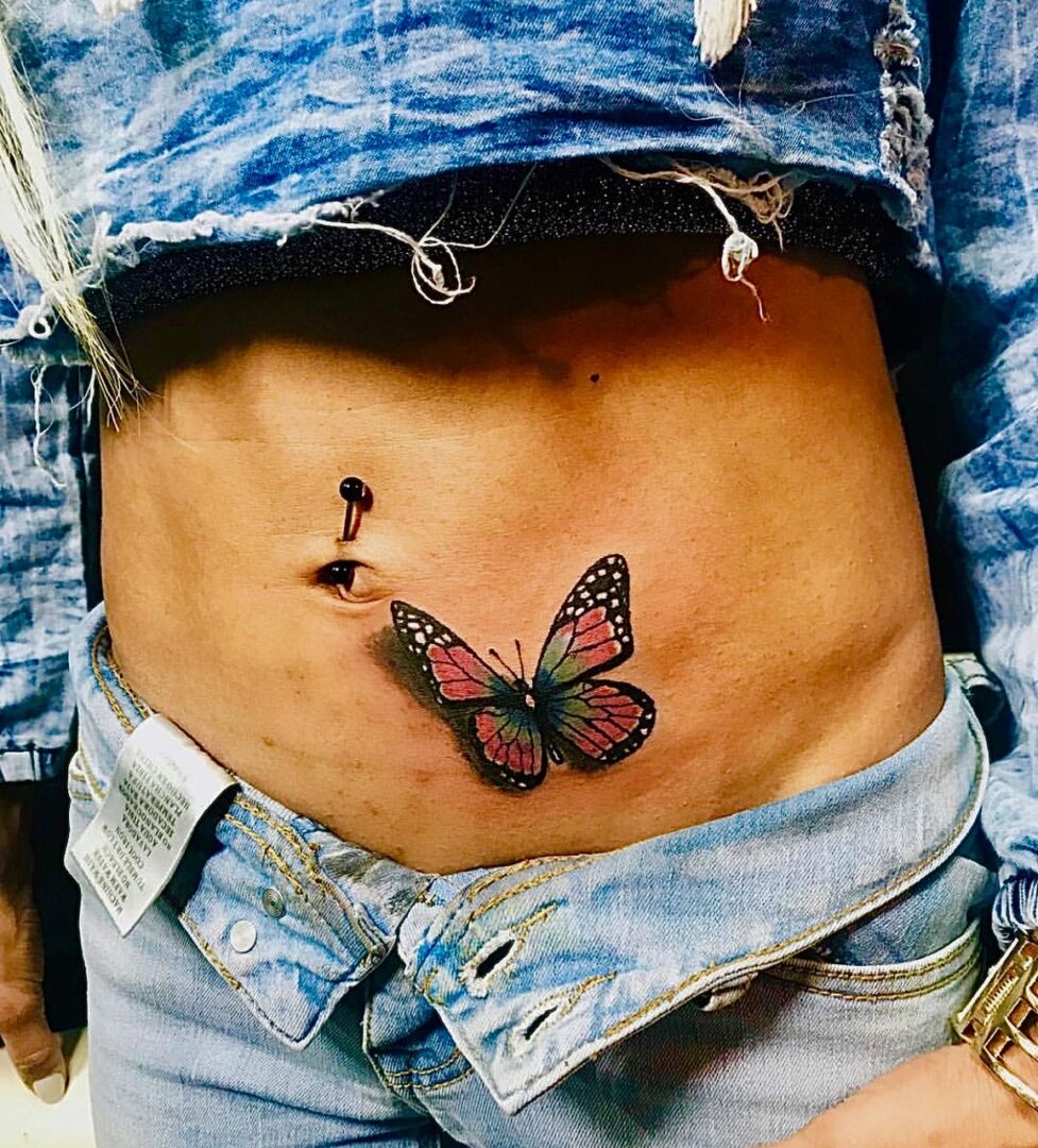 A woman with a butterfly tattoo on her stomach.
