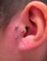A person with their ear pierced and showing off their piercings.