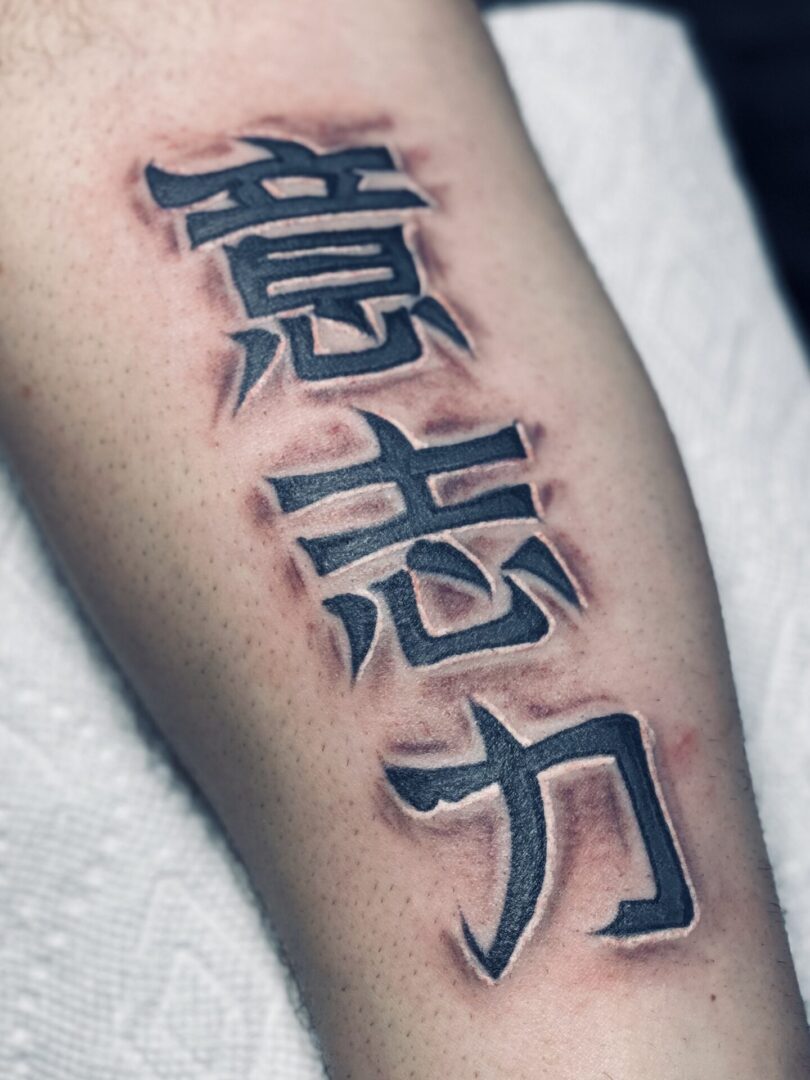A tattoo of chinese writing on the arm.