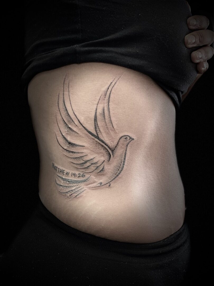 A person with a tattoo of a bird on their stomach.
