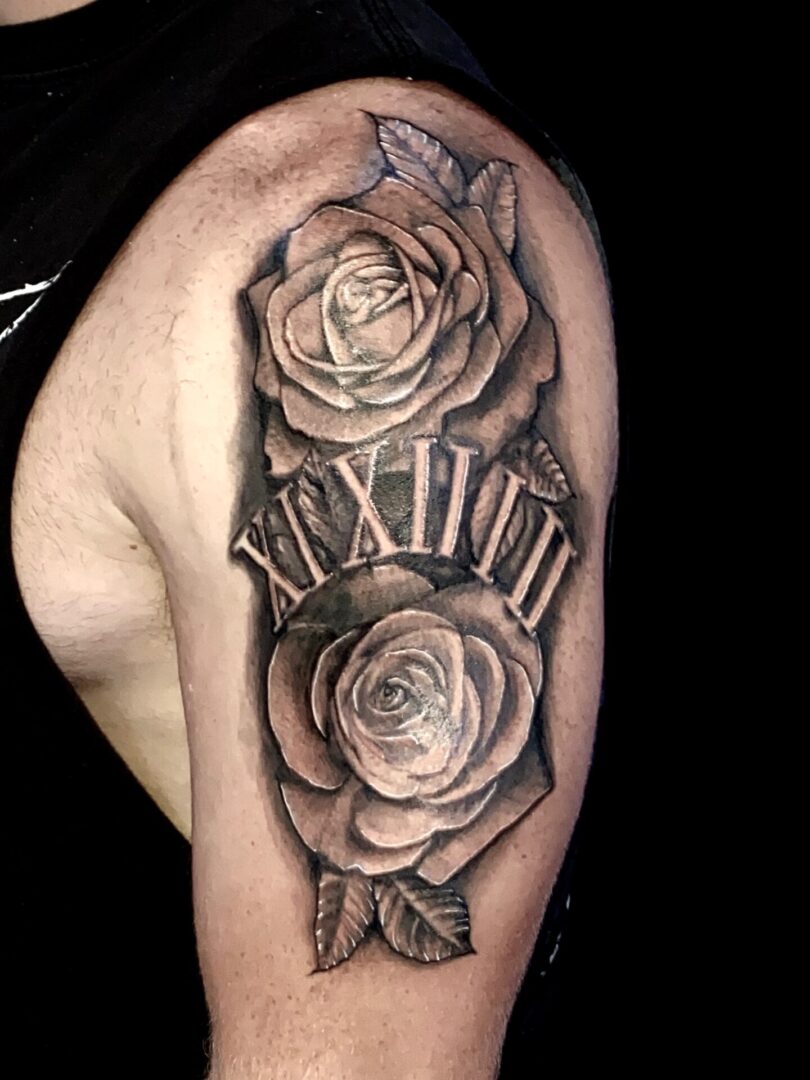 A man with a tattoo of roses and roman numerals.