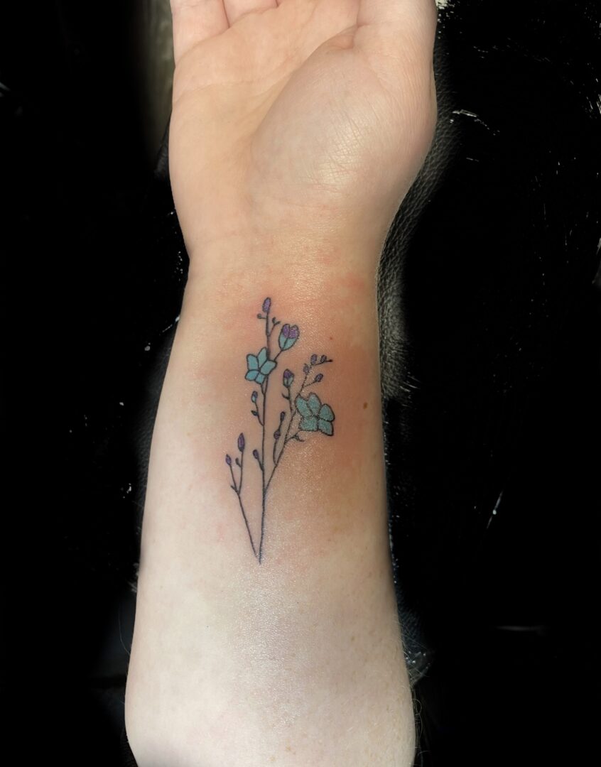 A small tattoo of flowers on the arm.