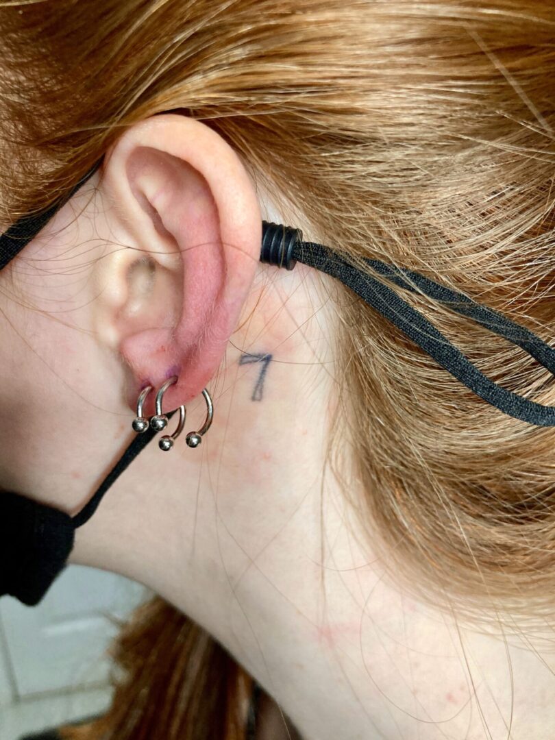 A woman with a number seven tattoo on her ear.