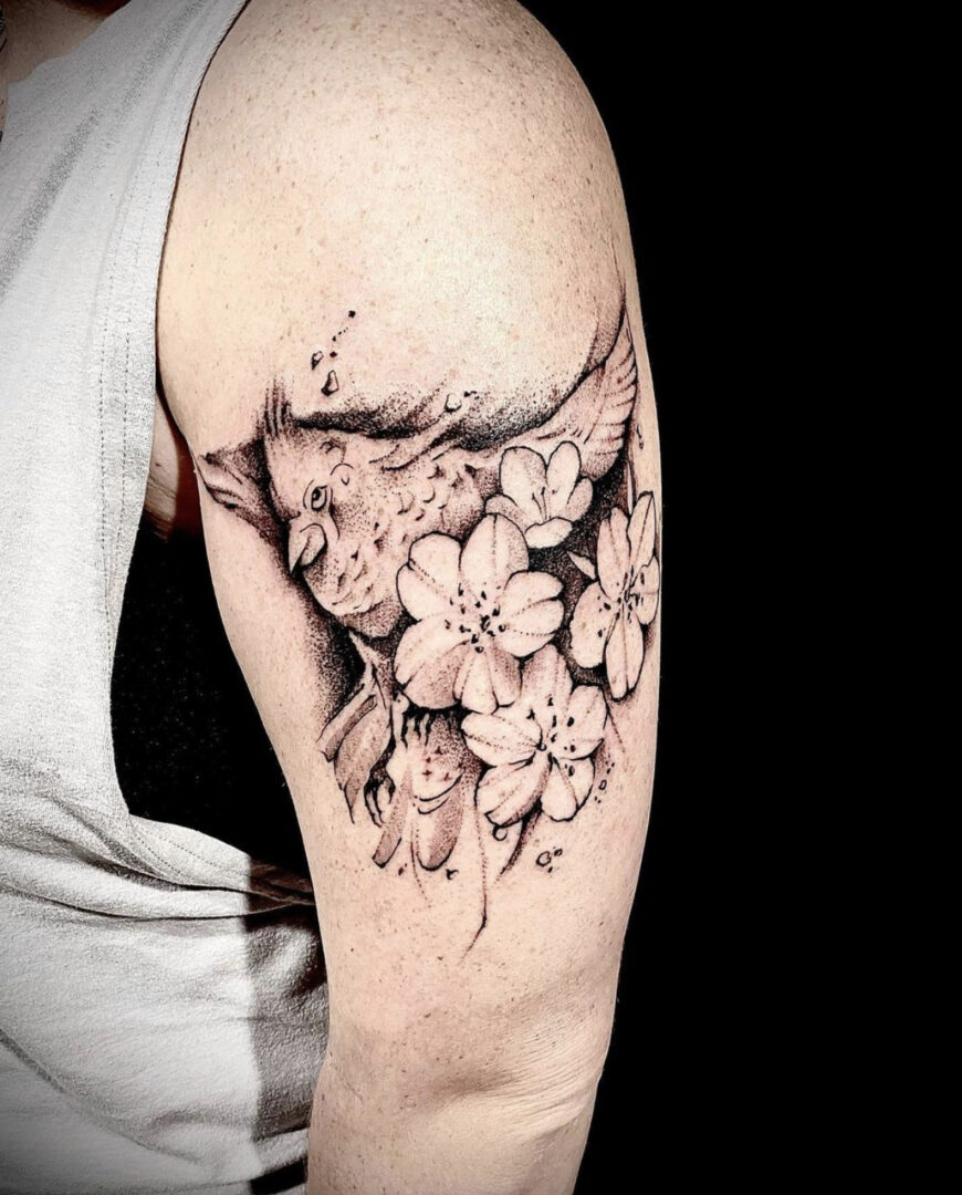 A black and white tattoo of flowers on the arm
