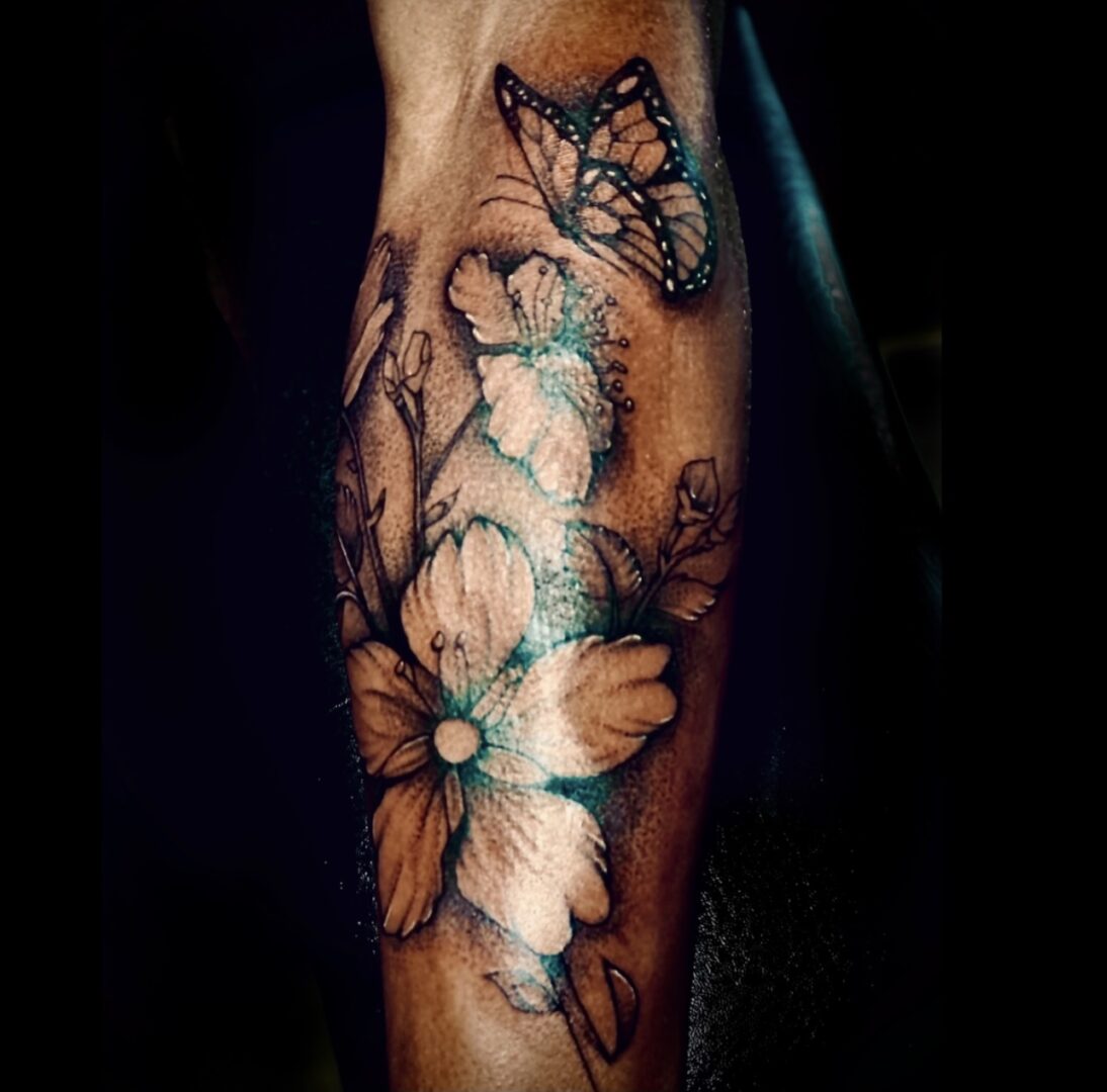 A tattoo of flowers and butterflies on the arm.