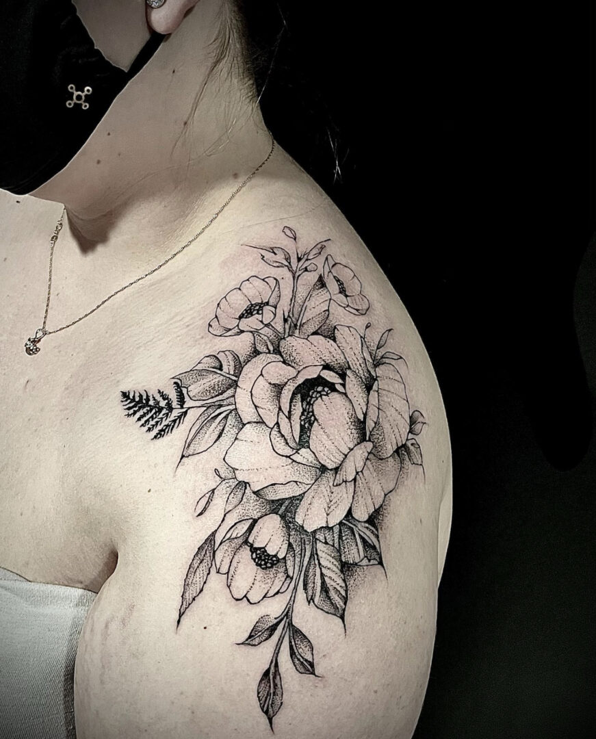 A woman with a tattoo of flowers on her shoulder.