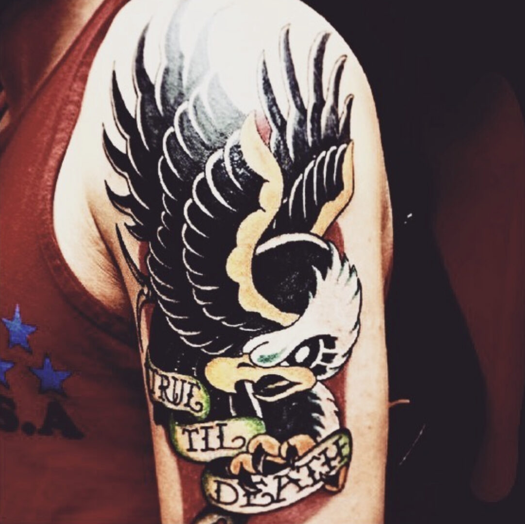A man with a tattoo of an eagle on his arm.