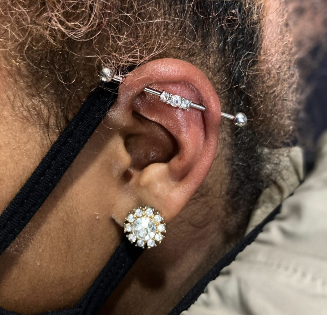 A man with his ear piercings and a diamond earring.