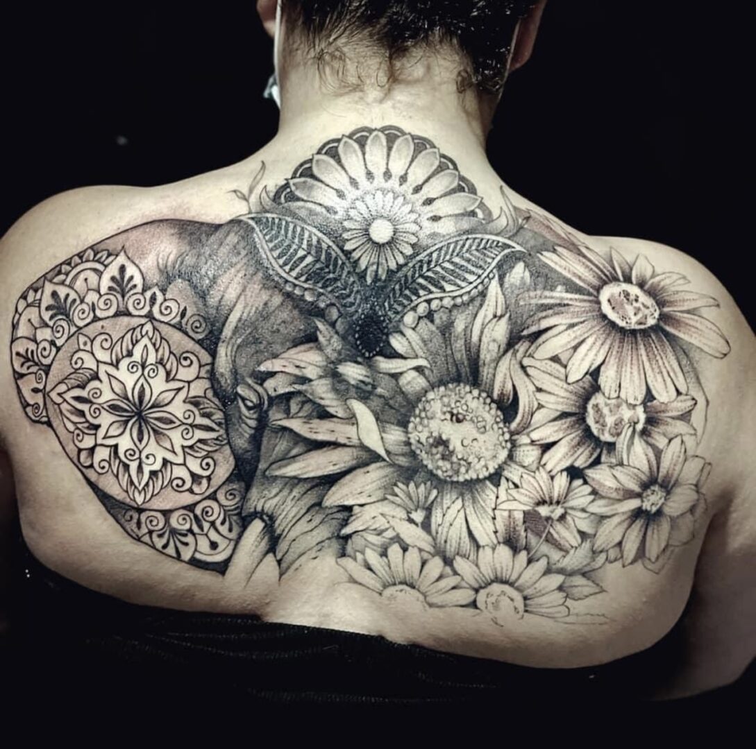 A woman with tattoos on her back and shoulder.