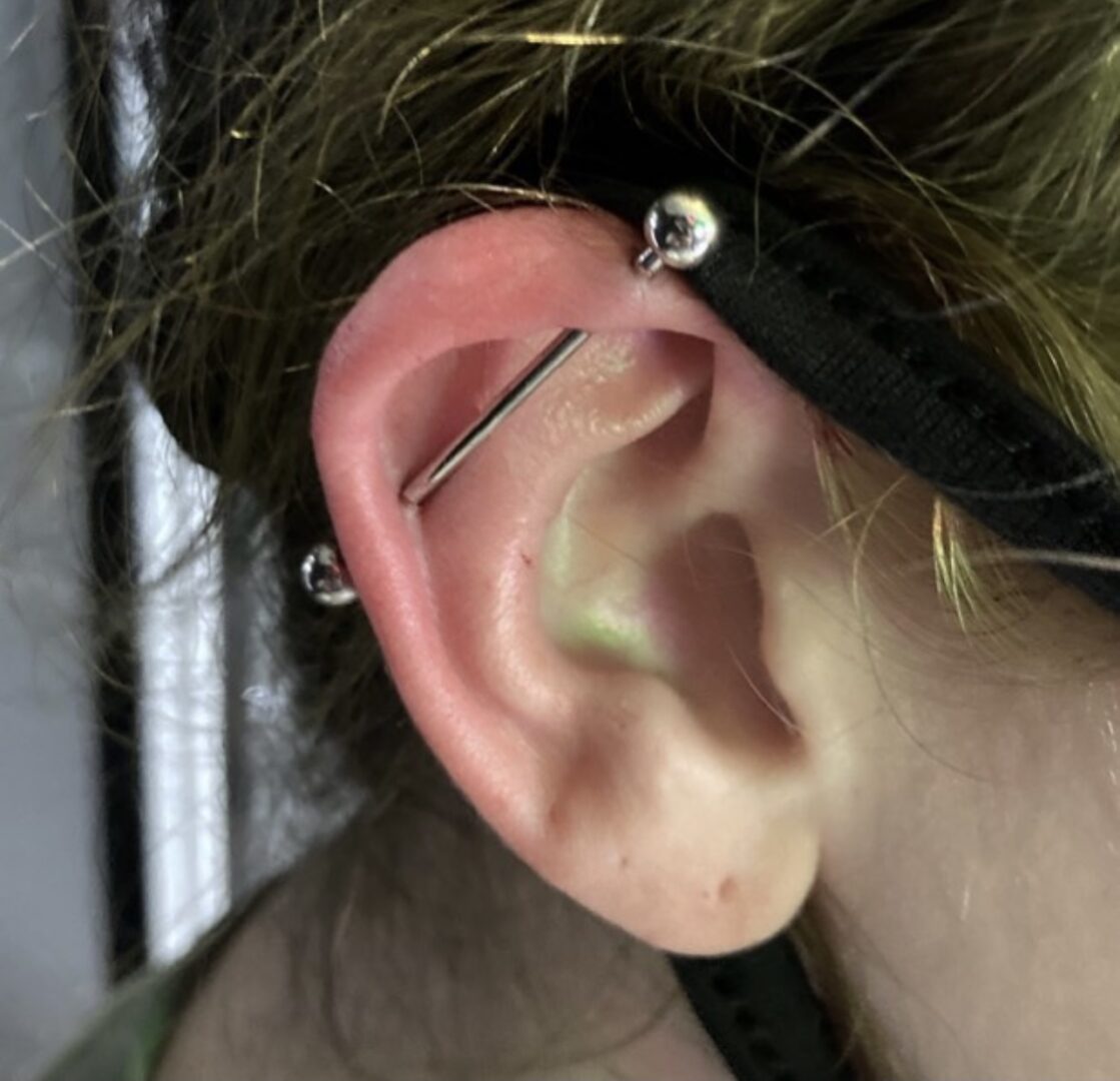 A person with their ear piercings and a black band