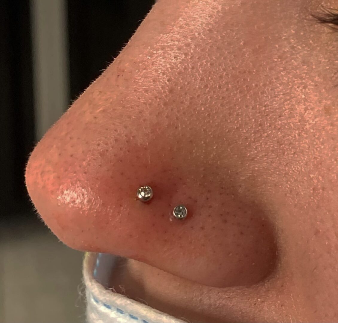 A close up of a person 's nose with a piercing