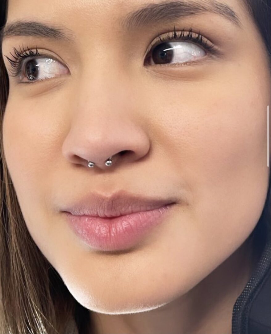 A close up of a person with a nose ring