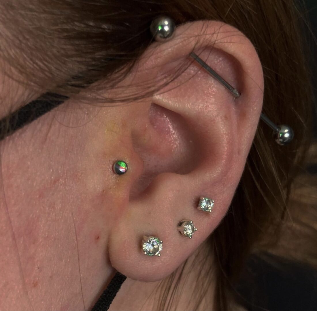 A woman with multiple piercings on her ear.