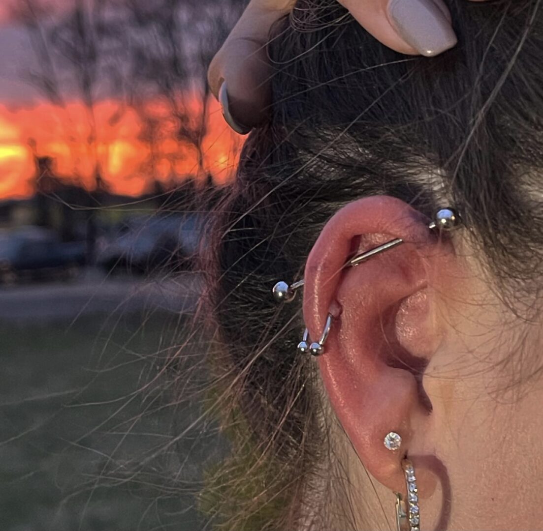 A woman with her ear piercings in the sun.