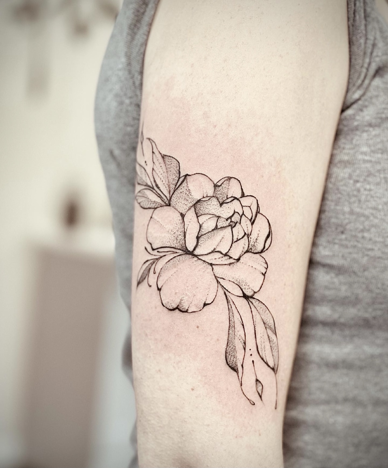 A woman with a tattoo of a flower on her arm.
