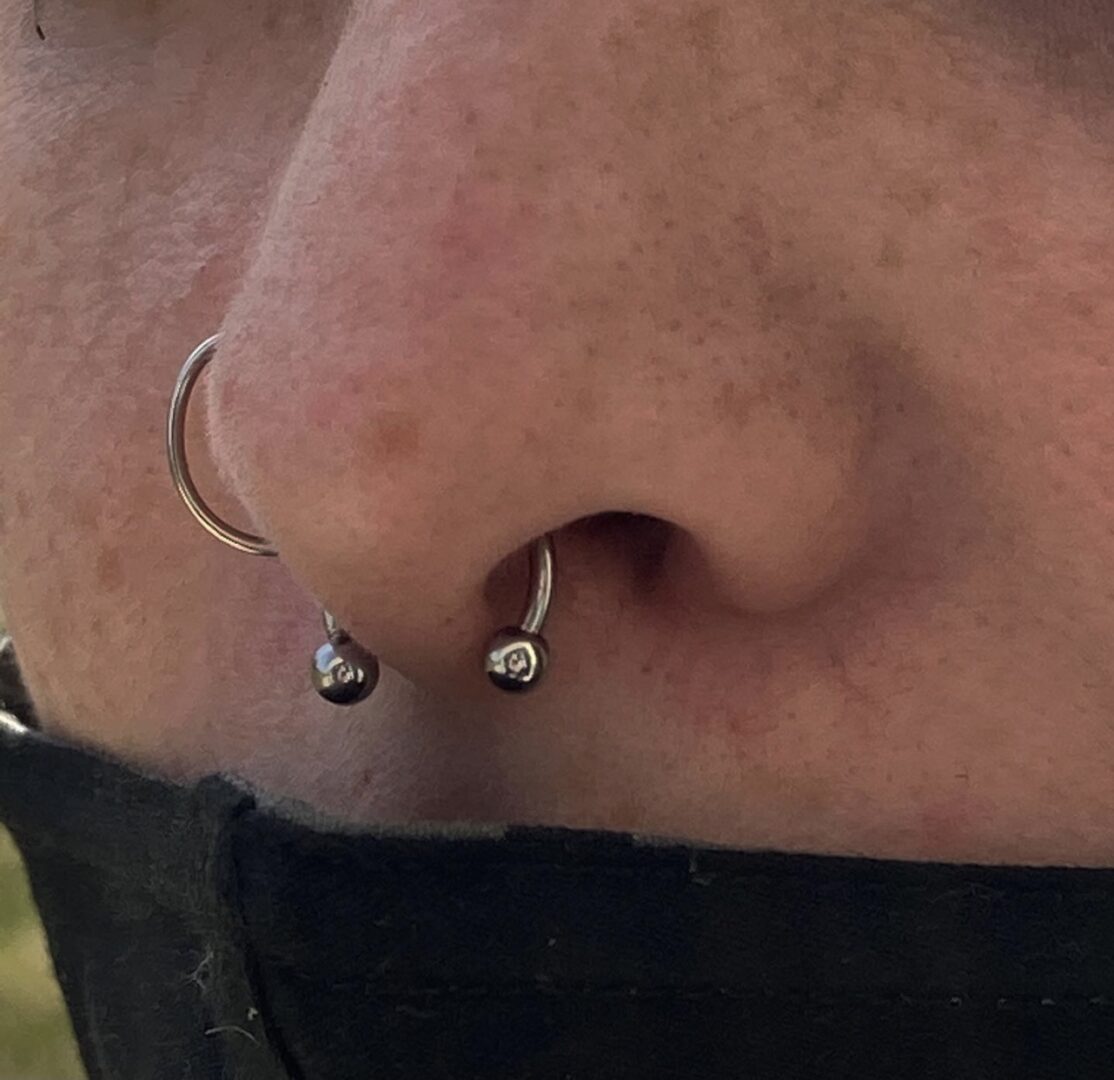A person with their nose ring pulled back.