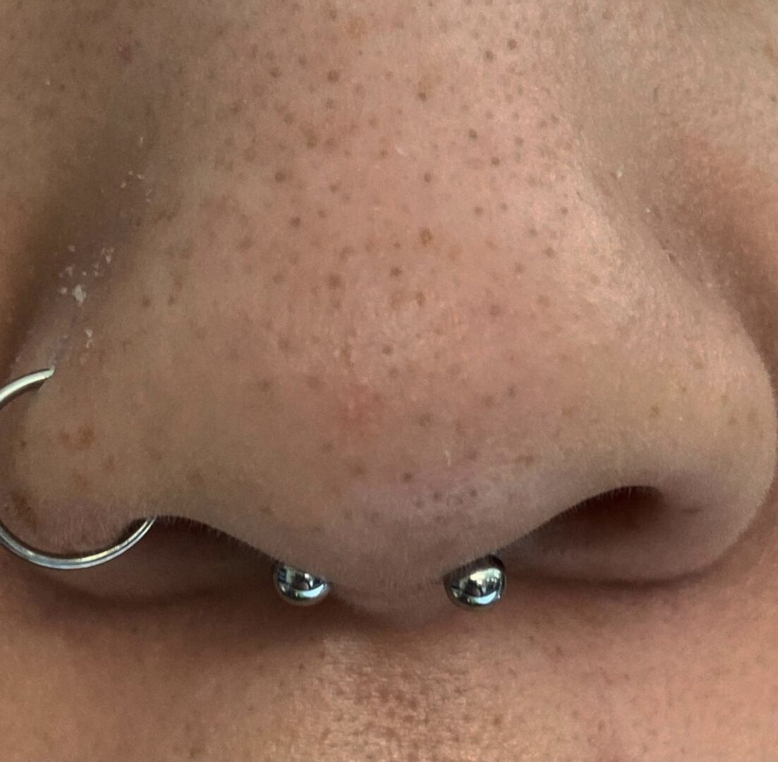 A close up of the nose with some piercings