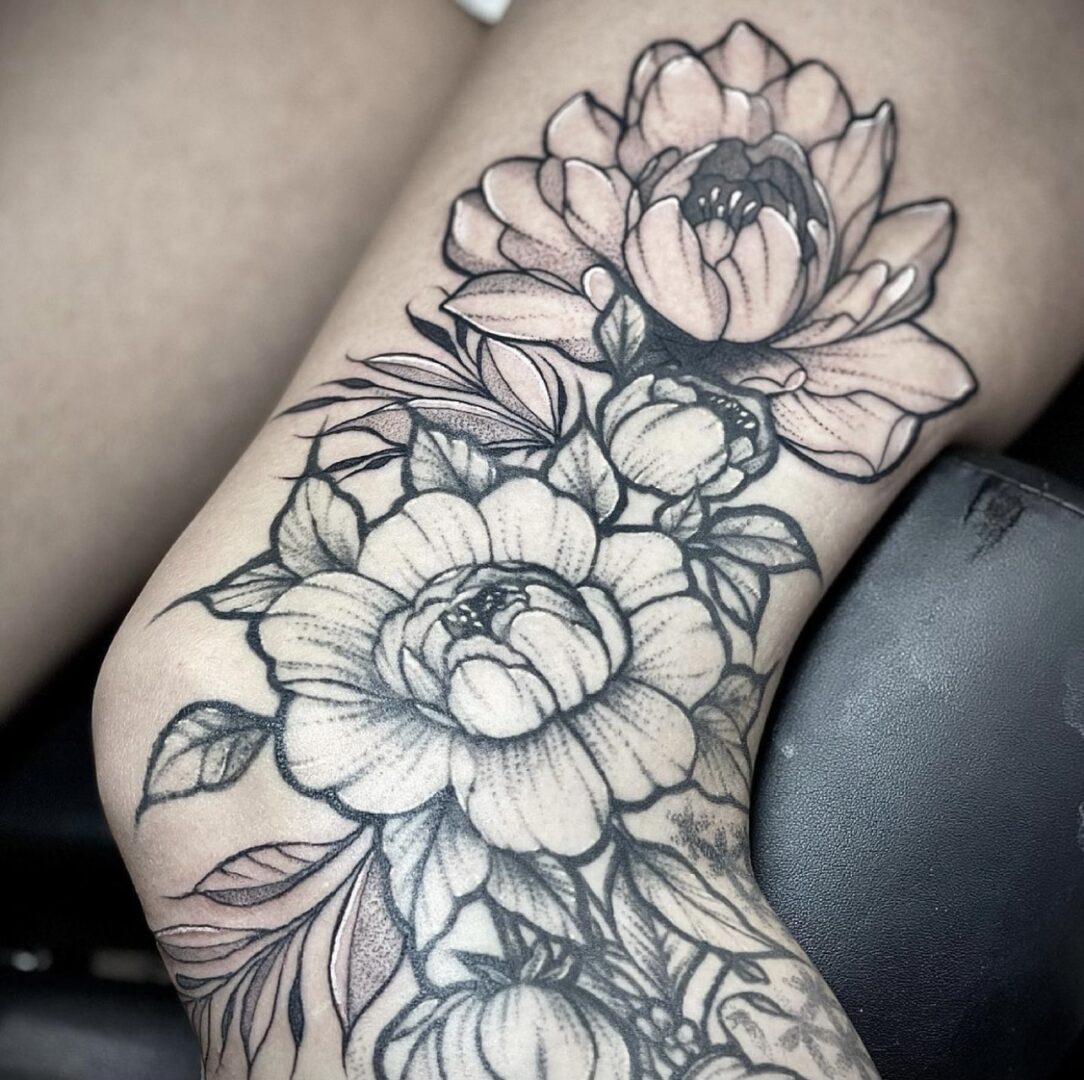 A woman with a tattoo of flowers on her leg.