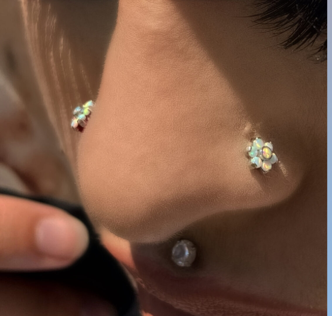 A person with their nose piercing and ear lobe.