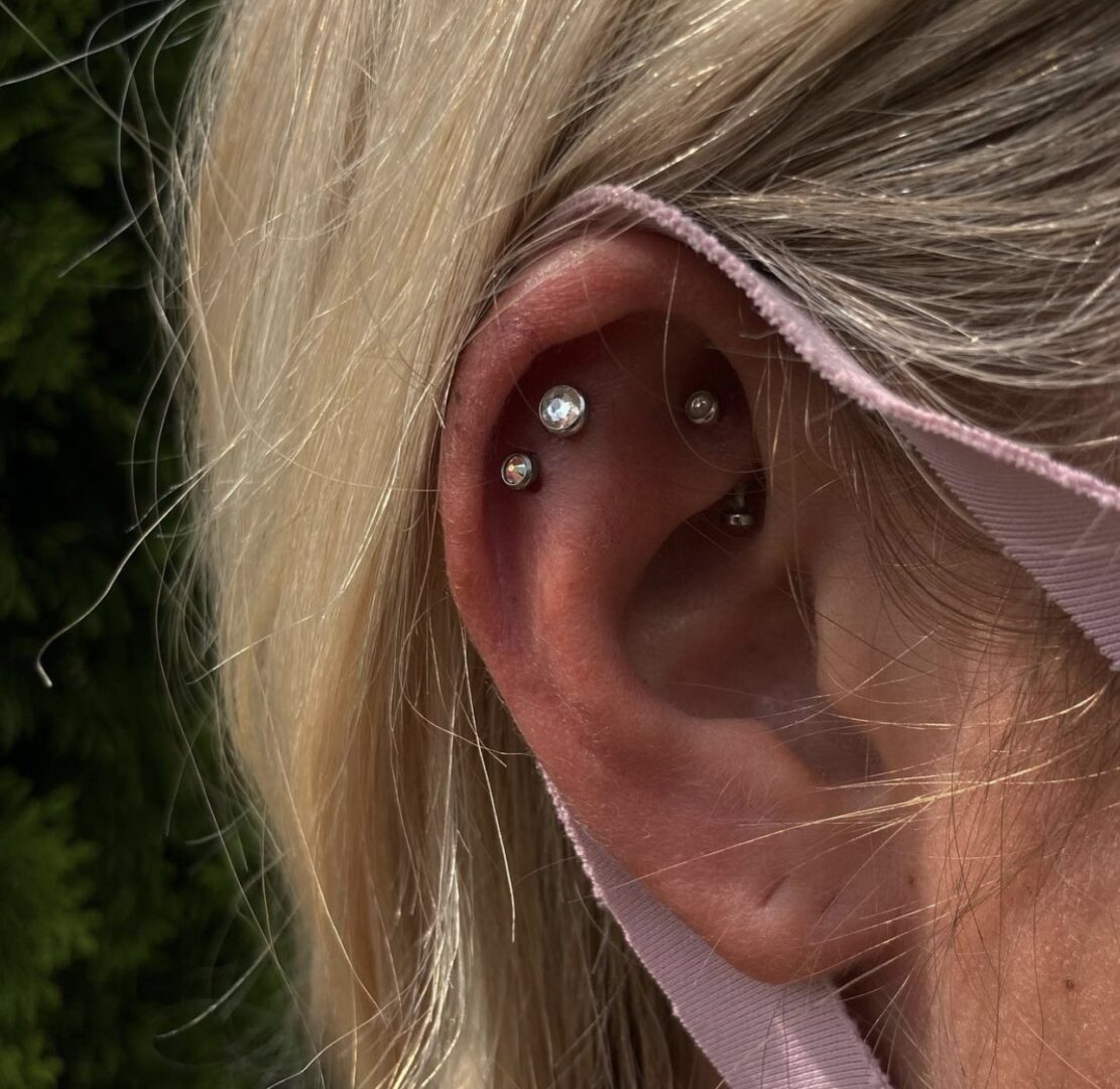 A woman with long blonde hair and a piercing in her ear.