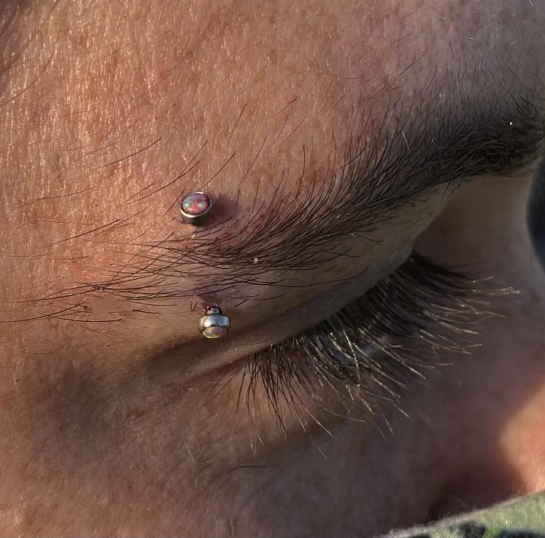 A close up of the eye with an ear piercing