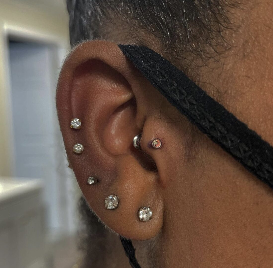 A man with multiple piercings on his ear.