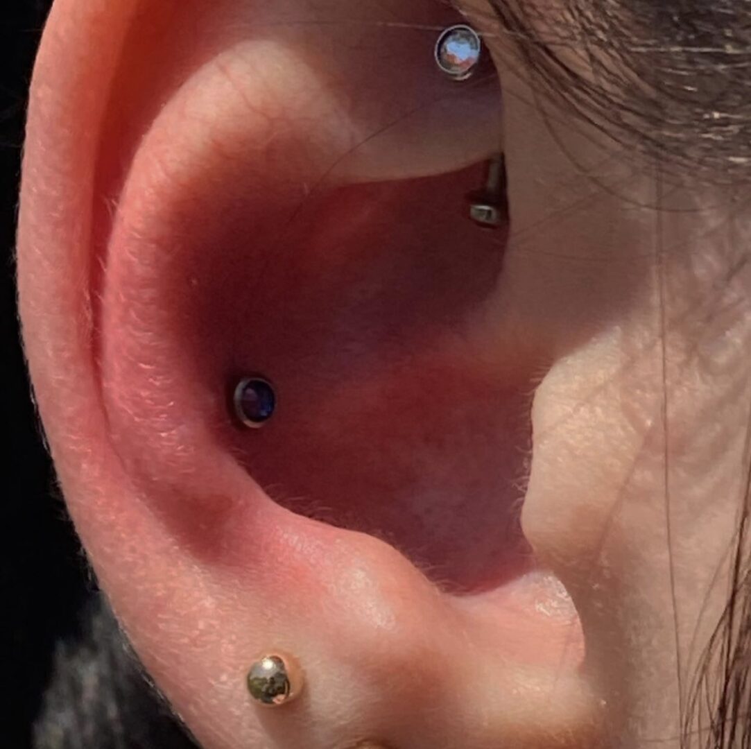 A person with their ear piercings in the ear.