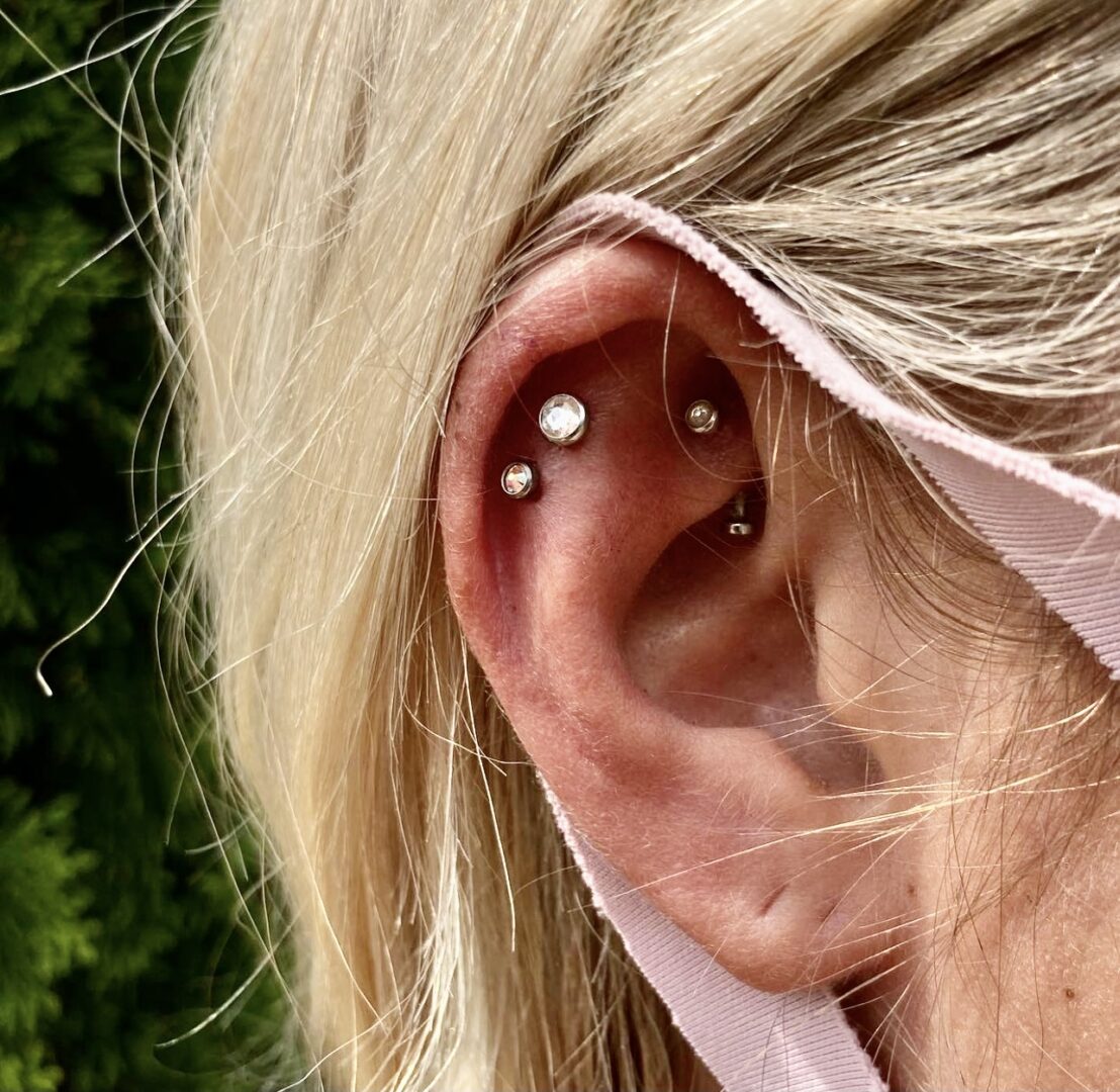 A woman with blonde hair and two piercings in her ear.