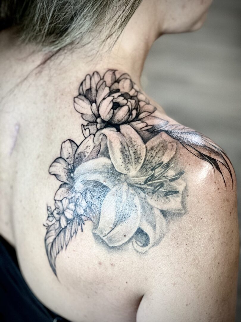 A woman with a tattoo of flowers on her shoulder.
