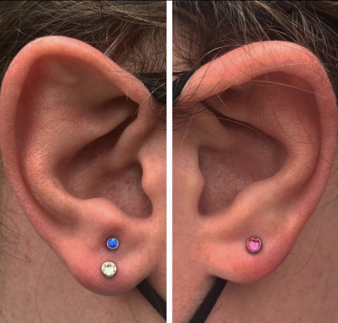 A woman 's ear with two different colored stones.