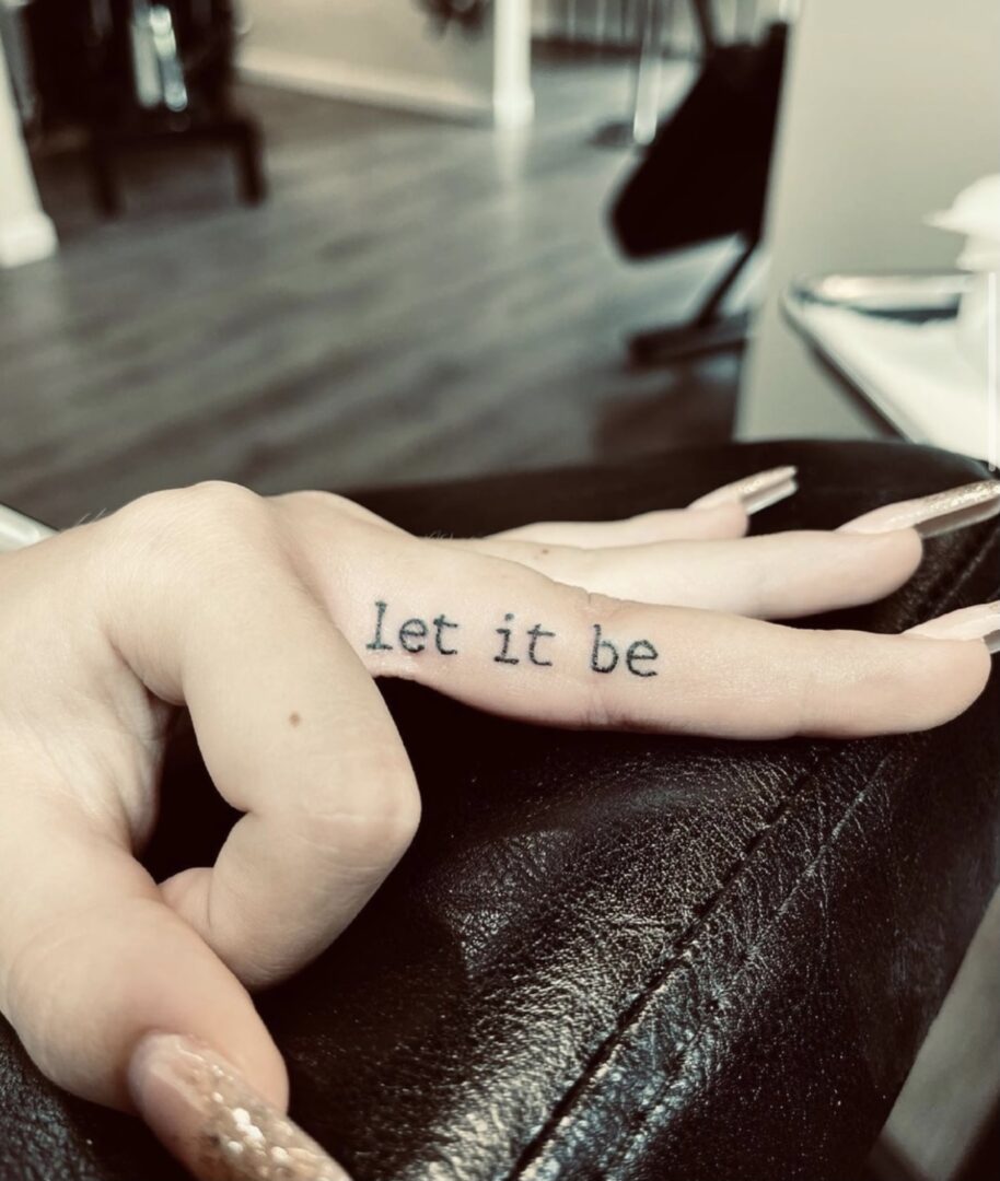 A person with their fingers crossed for the word let it be.