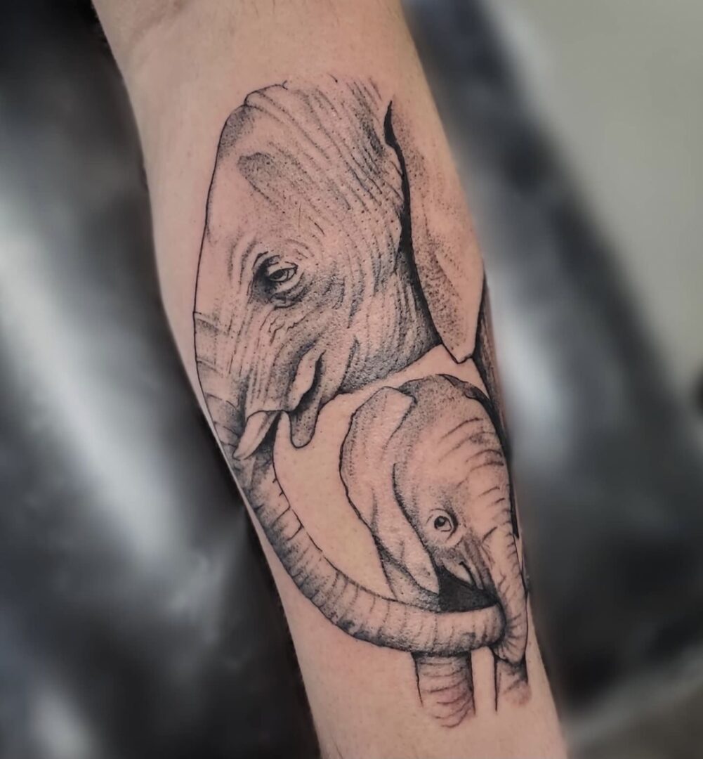 A tattoo of an elephant with its trunk around the head.