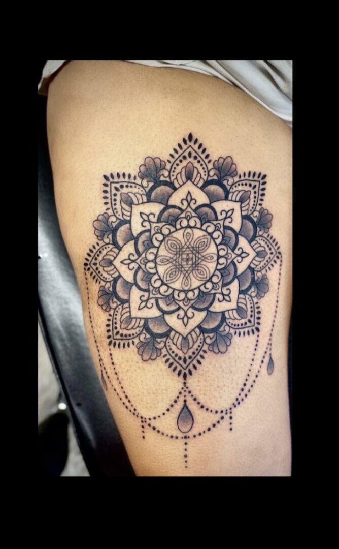 A tattoo of a mandala with chains on it.