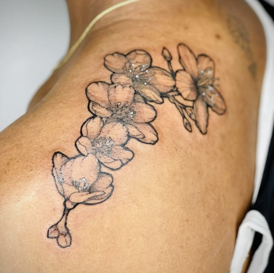 A tattoo of flowers on the side of a woman 's arm.