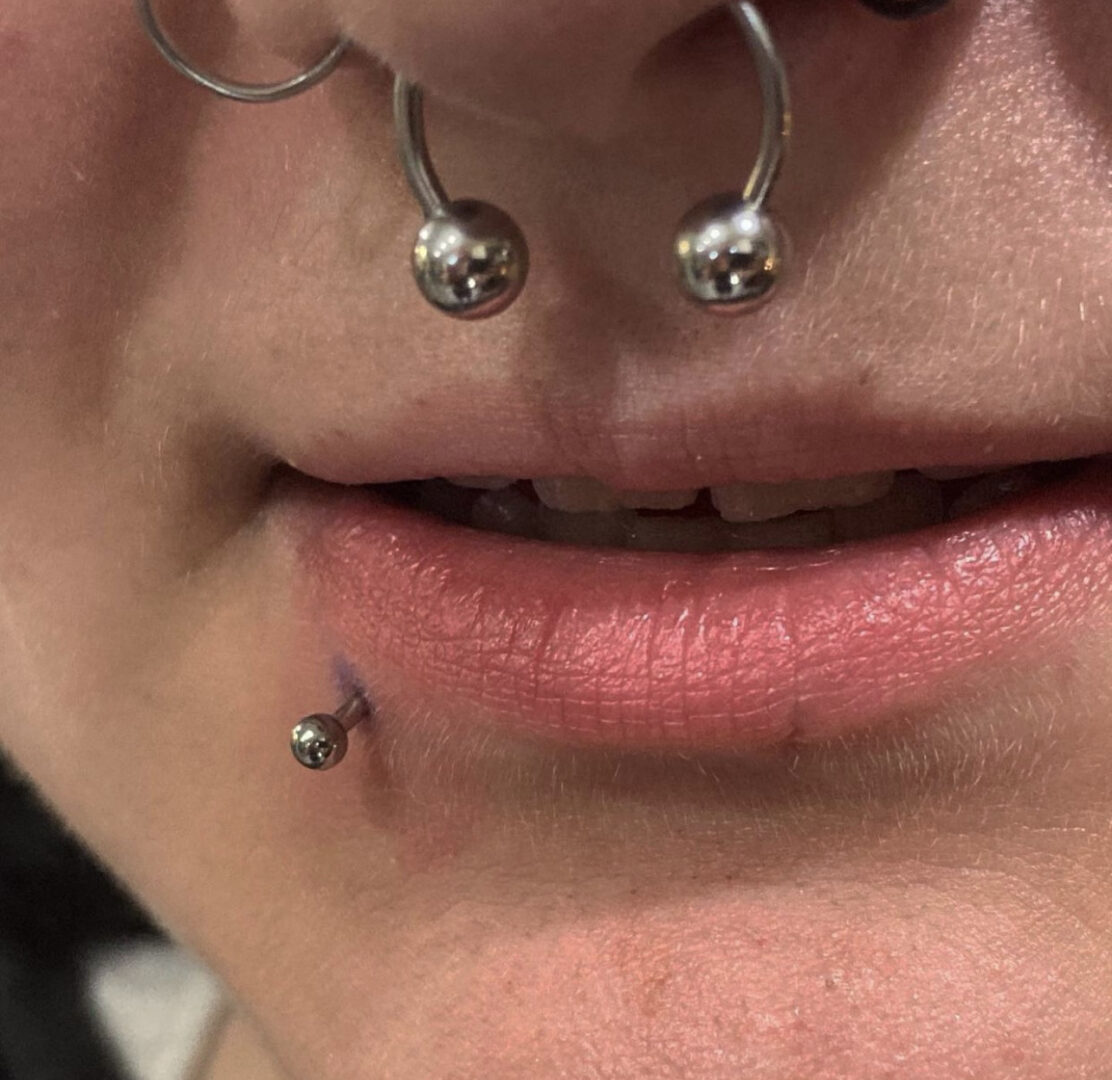 A woman with her nose ring and lip piercing.