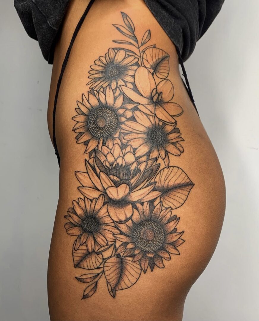 A woman with a tattoo of sunflowers on her hip.