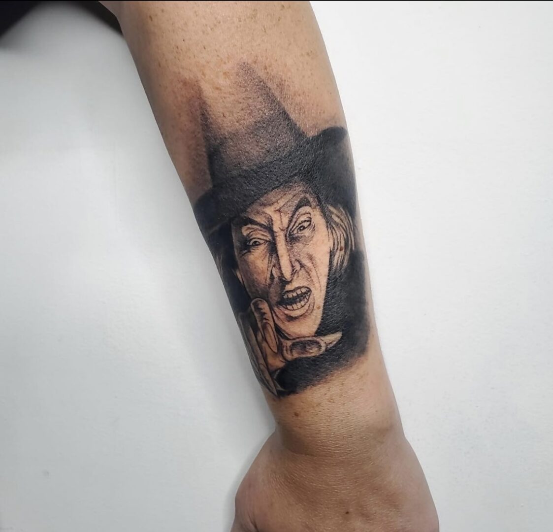 A man with a tattoo of a person wearing a hat.