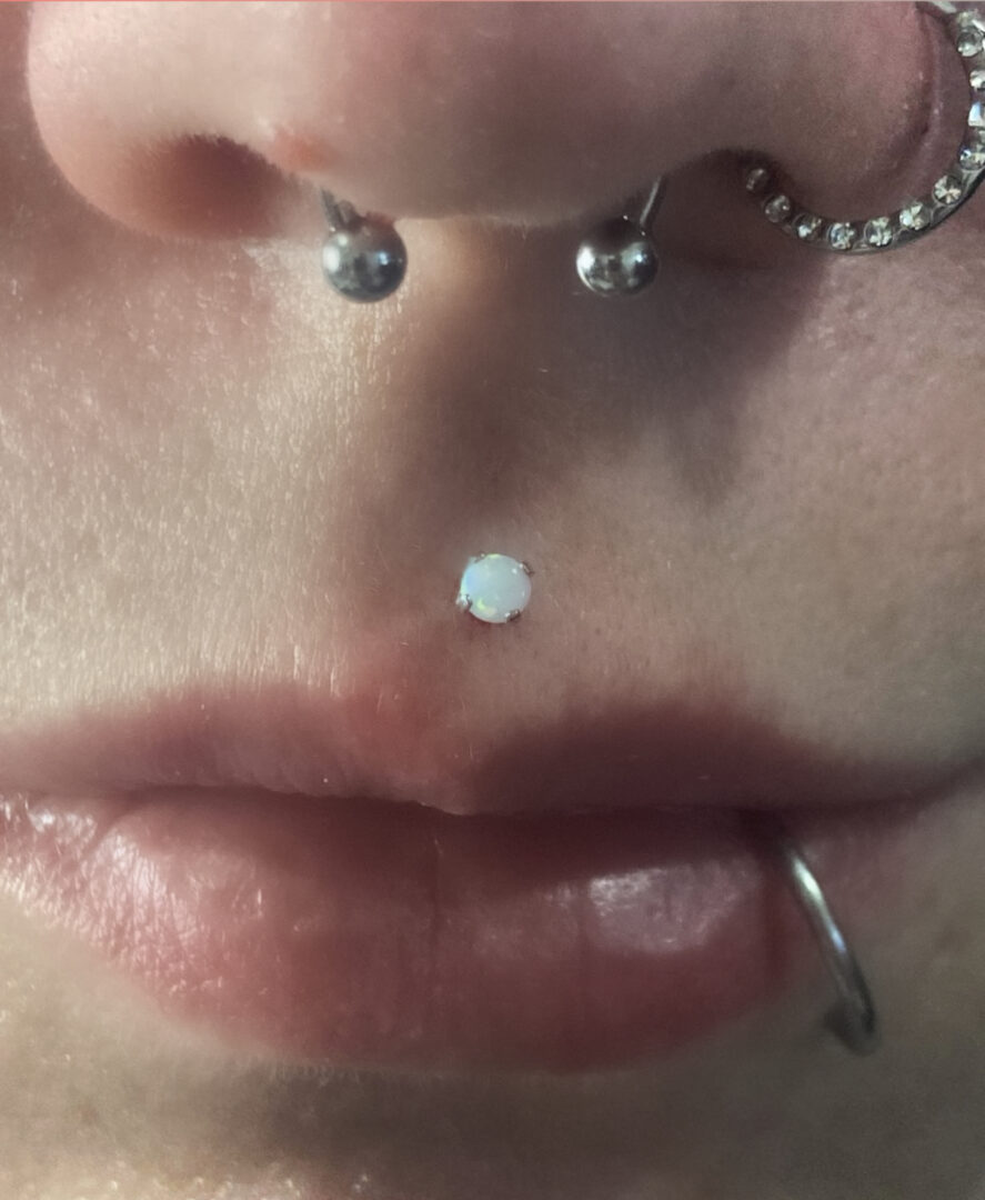 A woman with her nose piercing and white opal stone.