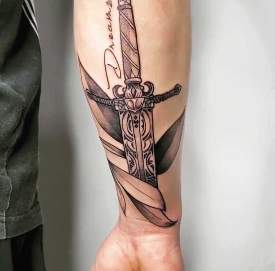 A man with a tattoo of a sword and a cross.