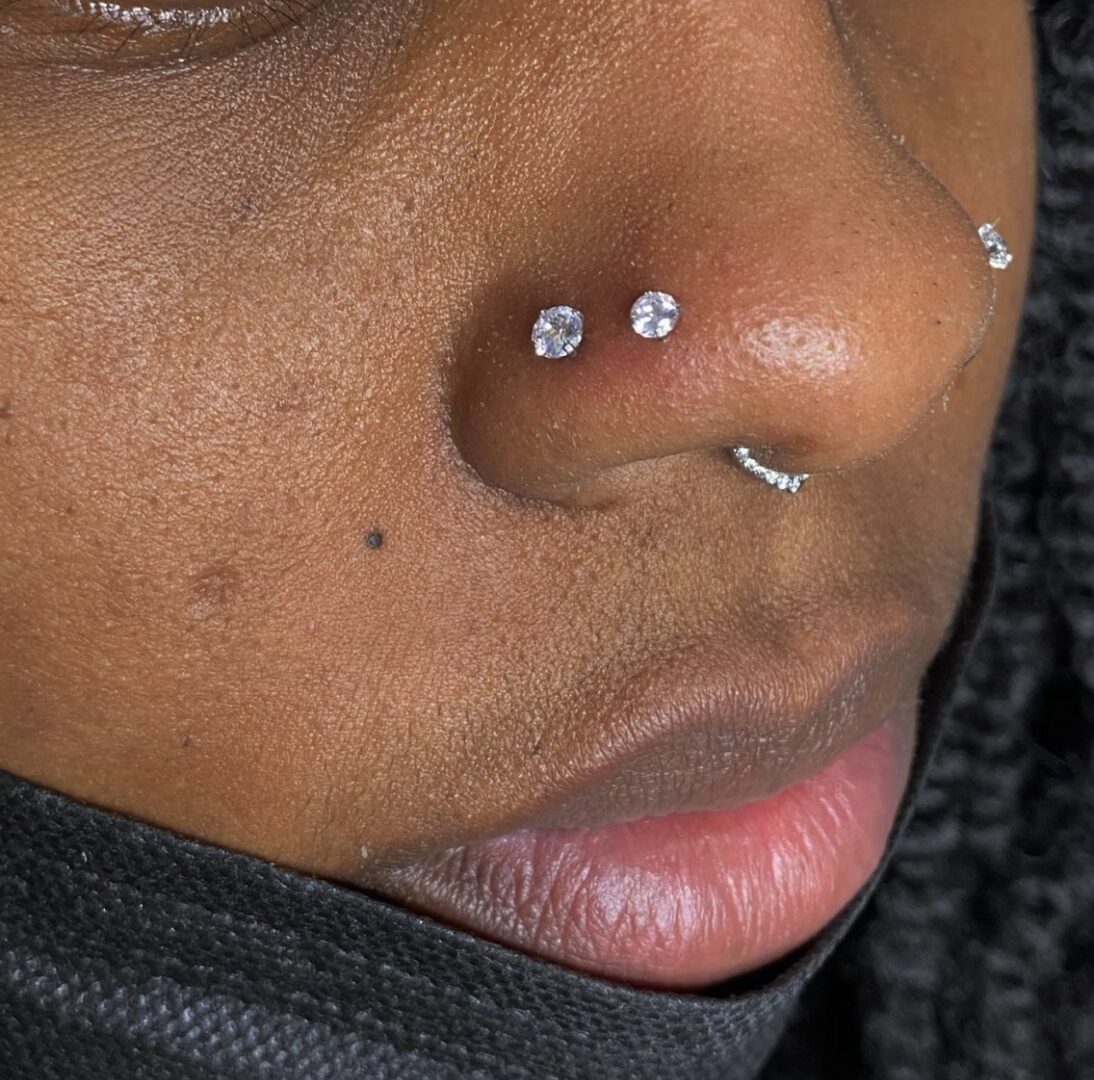 A woman with two piercings on her nose.