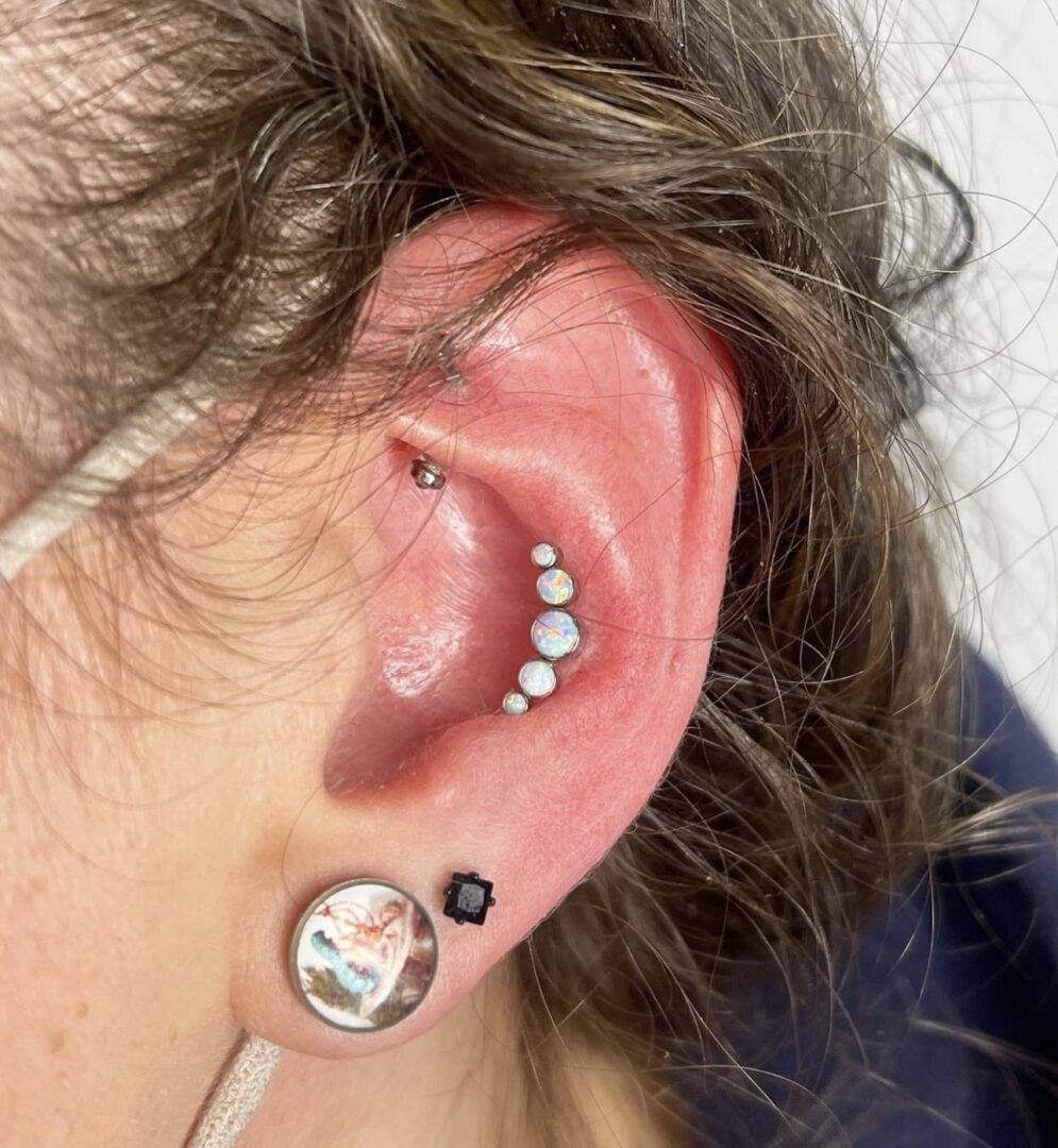A woman with her ear pierced with multiple piercings.