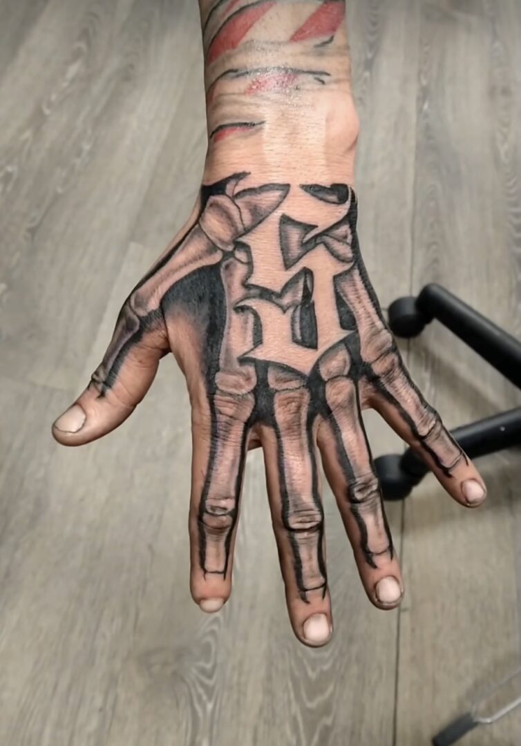 A hand with a skeleton tattoo on it.