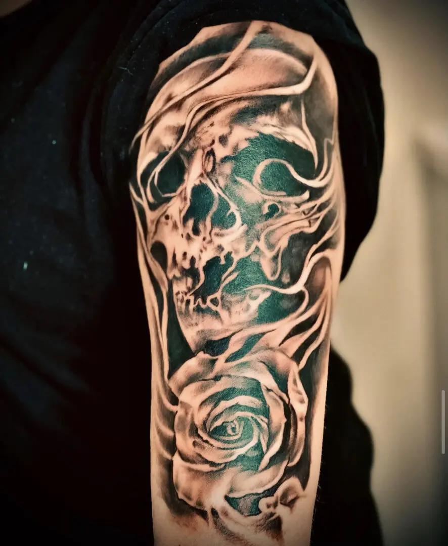 A man with a skull and rose tattoo on his arm.