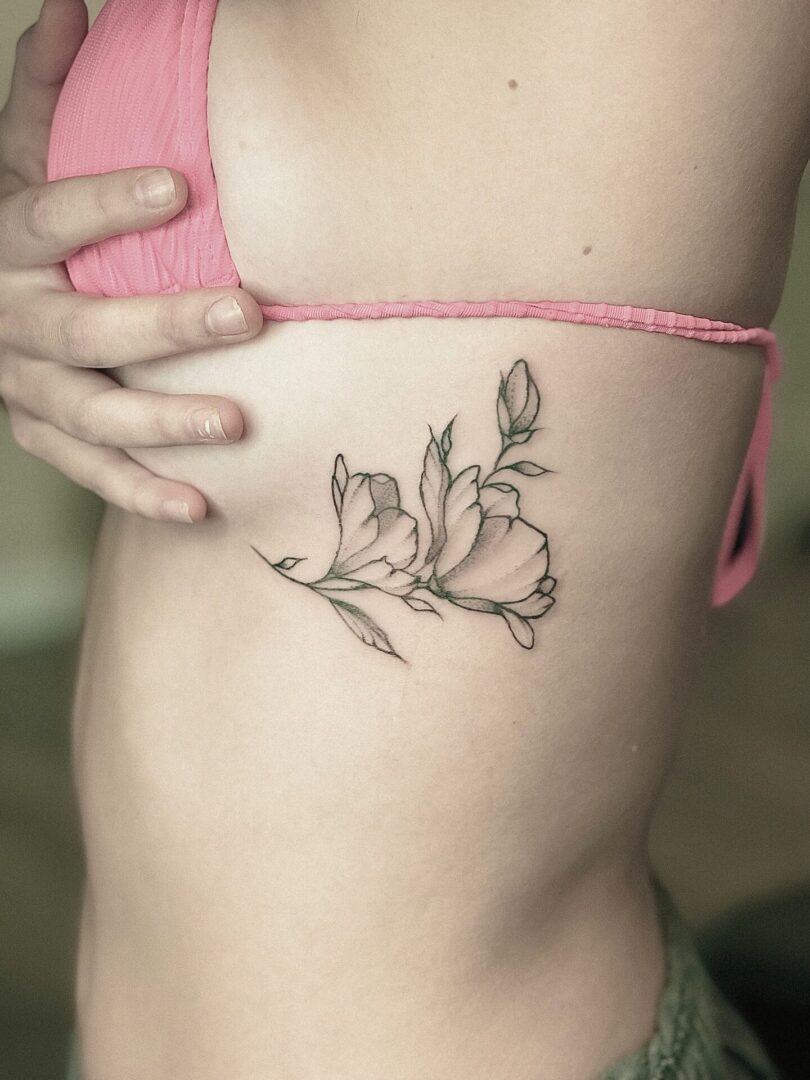 A woman with a tattoo of flowers on her stomach.